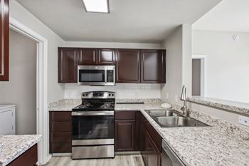 A kitchen with brown cabinets and a stainless steel oven